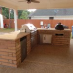 rose color chop rock outdoor kitchen in backyard