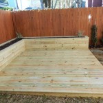 Treated wood deck with planter boxes in backyard
