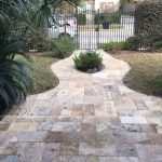 Front yard with stone steps and black wrought iron fencing