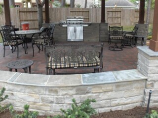 Grey chop rock outdoor kitchen,benches,stone columns and holland stone paver patio.