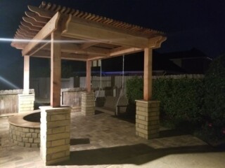 Cedar pergola with stone columns and curved stone bench